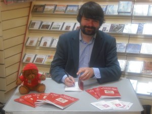 The author signing signing copies of the book (with the help of 'St Tedmund')